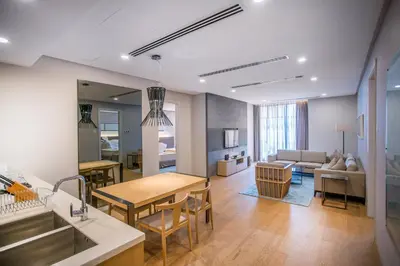 a kitchen and living room with a table and a couch at 188 Suites KLCC by CoBNB in Kuala Lumpur