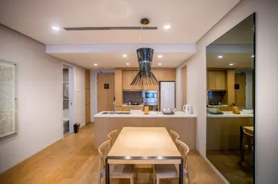 a dining room and kitchen with a table and chairs at 188 Suites KLCC by CoBNB in Kuala Lumpur