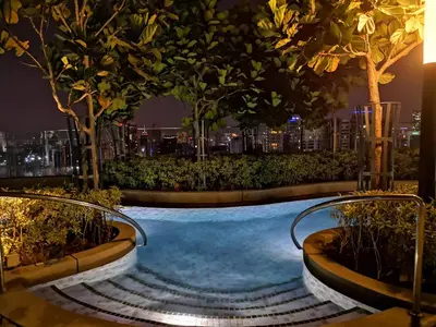 a swimming pool at night with a city in the background at Infini Suites@ The Robertson Bukit Bintang in Kuala Lumpur