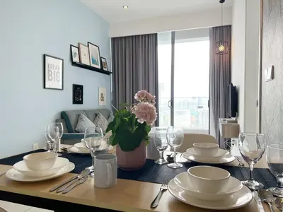 a dining room table with plates and a vase of flowers at Infini Suites@ The Robertson Bukit Bintang in Kuala Lumpur