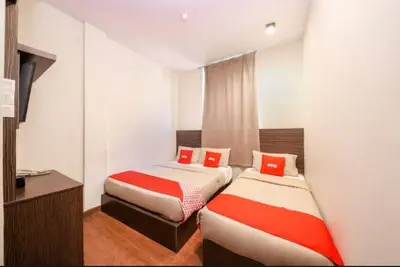 a room with two beds with red pillows at GOLDEN PALACE in Kuala Lumpur