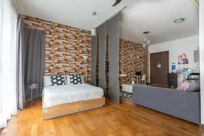 a bedroom with a bed and a brick wall at Cozy Regalia KL 吉隆玻 LRT & KTM @1 Parking & WIFI in Kuala Lumpur