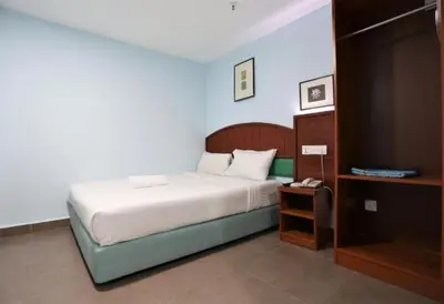 a bedroom with a bed with a nightstand and a bed sidx sidx sidx sidx at Orkid Hills Hotel at Bukit Bintang in Kuala Lumpur