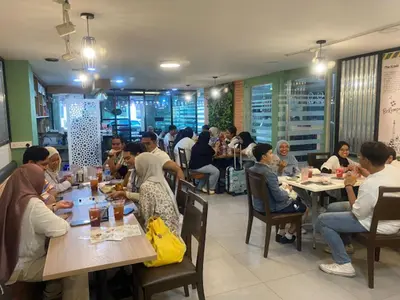a group of people sitting at tables in a restaurant at Orkid Hills Hotel at Bukit Bintang in Kuala Lumpur