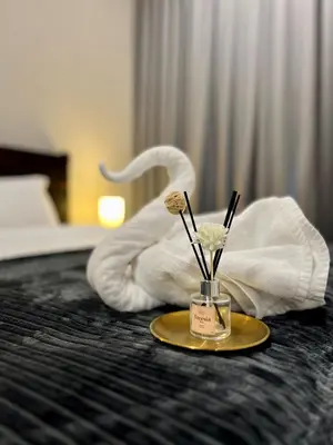 a hotel room with a plate with flowers on a bed at Opus Residence KL by EUcation Home in Kuala Lumpur