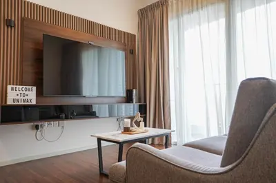a living room with a tv and a chair and a table at UNA Sunway Velocity Kuala Lumpur by Unimax in Kuala Lumpur