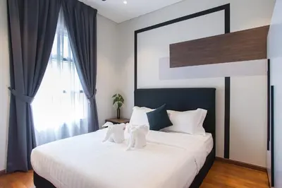 a bedroom with a large white bed with two teddy bears on it at GH KLCC Apartment by GuestHouse in Kuala Lumpur