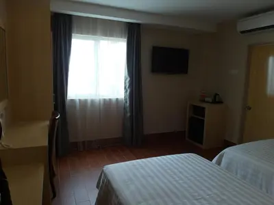a hotel room with two beds and a window at Metro Hotel @ KL Sentral in Kuala Lumpur