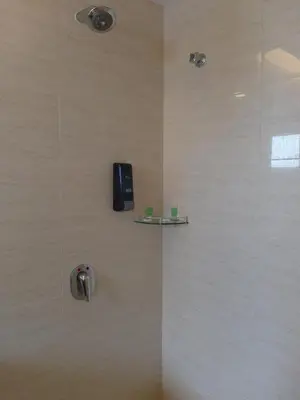 a shower with a black phone on a wall at Metro Hotel @ KL Sentral in Kuala Lumpur