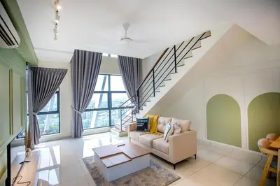 a living room with a couch and a staircase at Near MITEC, Arte Mont Kiara by Cobnb in Kuala Lumpur
