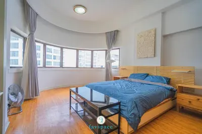a bedroom with a bed with a blue comforter and windows at Doorstep - Sunway Putra Mall - Close to PWTC for 4 in Kuala Lumpur