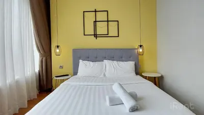 a bedroom with a white bed with two white towels on it at Private Room at Sky Suites KLCC by iRent365 in Kuala Lumpur