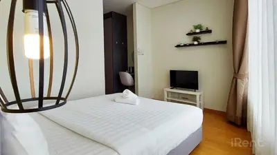 a bedroom with a white bed and a television at Private Room at Sky Suites KLCC by iRent365 in Kuala Lumpur