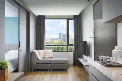 a bedroom with a couch and a window with a view at Hotel Komune Living & Wellness Kuala Lumpur in Kuala Lumpur