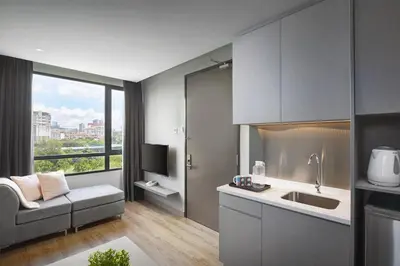 a kitchen with a sink and a couch in a room at Hotel Komune Living & Wellness Kuala Lumpur in Kuala Lumpur