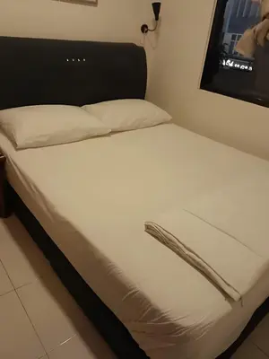 a bed with white sheets and pillows in a room at FKI INTERNATIONAL HOTEL in Kuala Lumpur