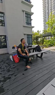 a man sitting on the ground next to a picnic table at ASTORIA AMPANG, 6Pax - Near KLCC, ZooNegara, AmpangPoint Mall in Kuala Lumpur