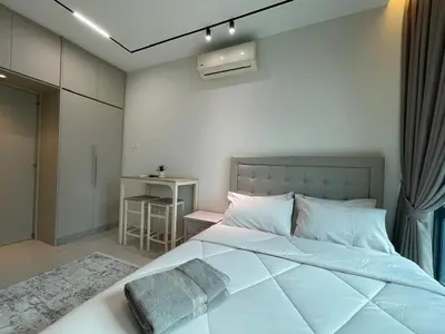 a bedroom with a large white bed and a table at Legasi Kampung Baru Guesthouse in Kuala Lumpur