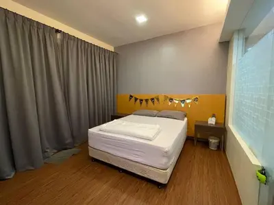 a bedroom with a bed with white sheets on it at Private Jacuzzi Staycation at KL City 1014 in Kuala Lumpur
