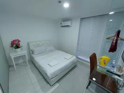 a white room with a bed and a table at ONE AMPANG HOTEL in Ampang