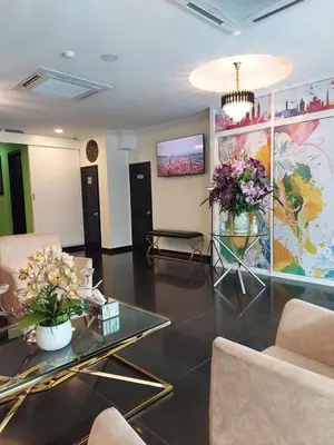 a living room with two chairs and a table with flowers at ONE AMPANG HOTEL in Ampang