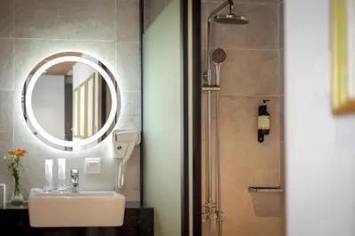a bathroom with a sink and a mirror and a shower at Santa Grand Classic Kuala Lumpur, Chinatown in Kuala Lumpur