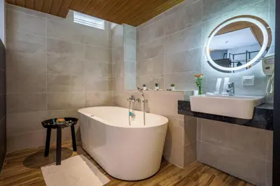 a bathroom with a tub and a sink and a mirror at Santa Grand Classic Kuala Lumpur, Chinatown in Kuala Lumpur