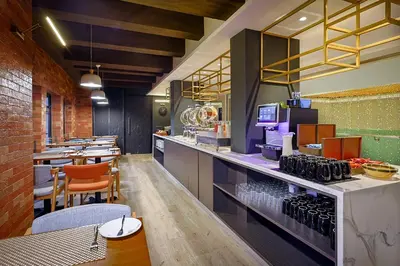a restaurant with a bar with tables and chairs at Santa Grand Classic Kuala Lumpur, Chinatown in Kuala Lumpur