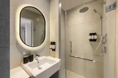 a bathroom with a sink and a mirror and a shower at lyf Chinatown Kuala Lumpur in Kuala Lumpur