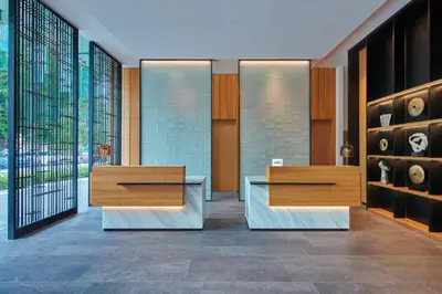 a lobby with two tables and shelves with vases at Fairfield by Marriott Chow Kit Kuala Lumpur in Kuala Lumpur