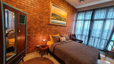 a bedroom with a brick wall with a bed and a window at Rumah Kampong Bharu near KLCC (3Rooms) in Kuala Lumpur