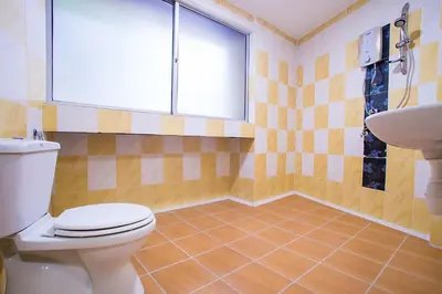 a bathroom with a toilet and a sink and a window at MK Inn Hotel in Kuala Lumpur