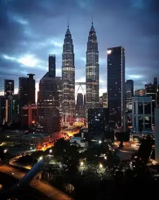 a view of a city skyline at night at Legasi Kampung Baru apartment by Rumahrehat twin tower view in Kuala Lumpur