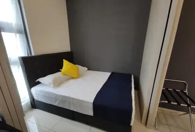 a small bedroom with a bed with a yellow pillow at MyCribKL The Robertson 2 Bedroom Bukit Bintang in Kuala Lumpur