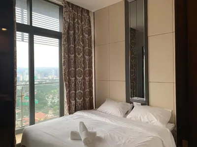 a bedroom with a bed with white sheets and a window at Nana's at Dorsett Residence Bukit Bintang in Kuala Lumpur
