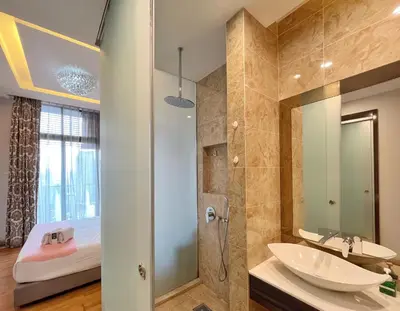 a bathroom with a sink and a shower and a bed at Nana's at Dorsett Residence Bukit Bintang in Kuala Lumpur
