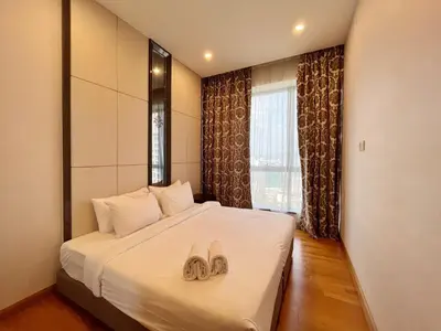 a hotel room with a bed with two slippers on it at Nana's at Dorsett Residence Bukit Bintang in Kuala Lumpur