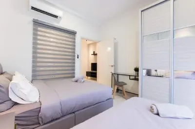 a bedroom with two beds and a desk at Arte Mont Kiara 3pax Jacuzzi Pool Gym near MITEC Matrade in Kuala Lumpur