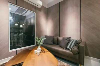 a living room with a couch and a wooden table at Arte Mont Kiara 3pax Jacuzzi Pool Gym near MITEC Matrade in Kuala Lumpur