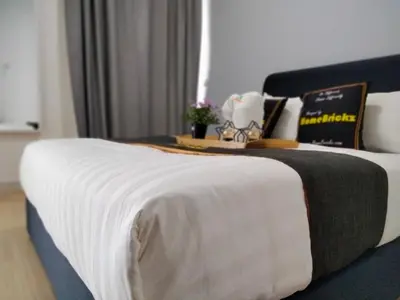 a bed in a hotel room with a white blanket at Continew Residence by HomeBrickz in Kuala Lumpur