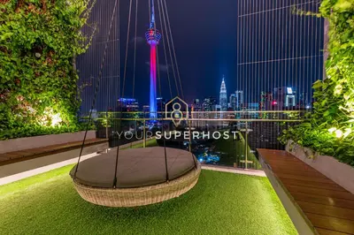 a hammock on a balcony with a view of the city at Ceylonz Suites nr Pavilion & KLCC by YourSuperhost in Kuala Lumpur