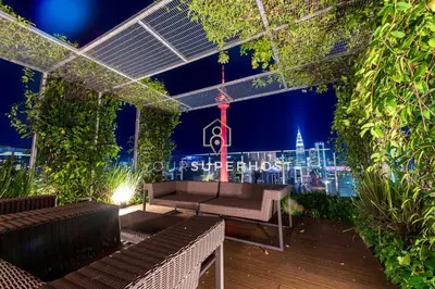 a rooftop patio with a bench and a city skyline at night at Ceylonz Suites nr Pavilion & KLCC by YourSuperhost in Kuala Lumpur