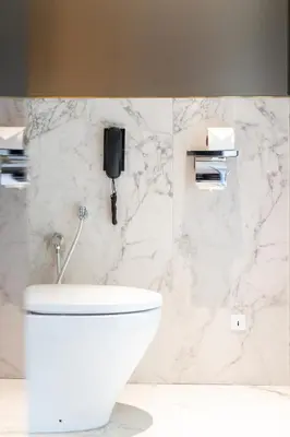 a bathroom with a toilet and a phone on the wall at WOLO Kuala Lumpur in Kuala Lumpur