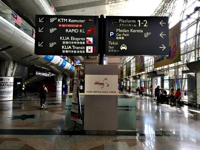 an airport terminal with signs and people walking around at KL Sentral Loft, EST Bangsar #3A in Kuala Lumpur