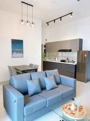 a blue couch in a living room with a kitchen at TR Residence Near Titiwangsa LRT By Iconique in Kuala Lumpur