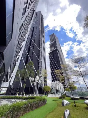 two tall buildings in a city with a park at Modern Suites at Arte Mont Kiara BY Iconique in Kuala Lumpur