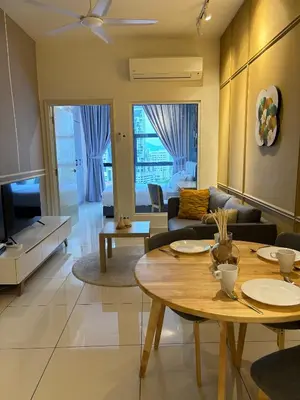 a living room with a table and a couch at Modern Suites at Arte Mont Kiara BY Iconique in Kuala Lumpur