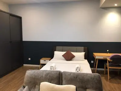 a bedroom with a bed with two dogs on a couch at Ceylonz Suite Official in Kuala Lumpur