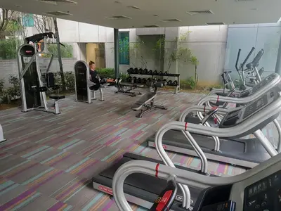 a gym with several treadmills and a person in the background at KLCC Gem walk to all in Kuala Lumpur