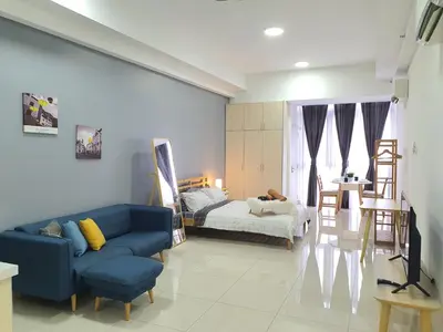 a living room with a blue couch and a bedroom at Vivo Soho Suite @ Mid Valley Old Klang Road KL in Kuala Lumpur